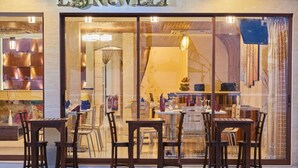 A restaurant with a modern interior, visible through large glass windows. - Lonuveli (Hulhumalé)
