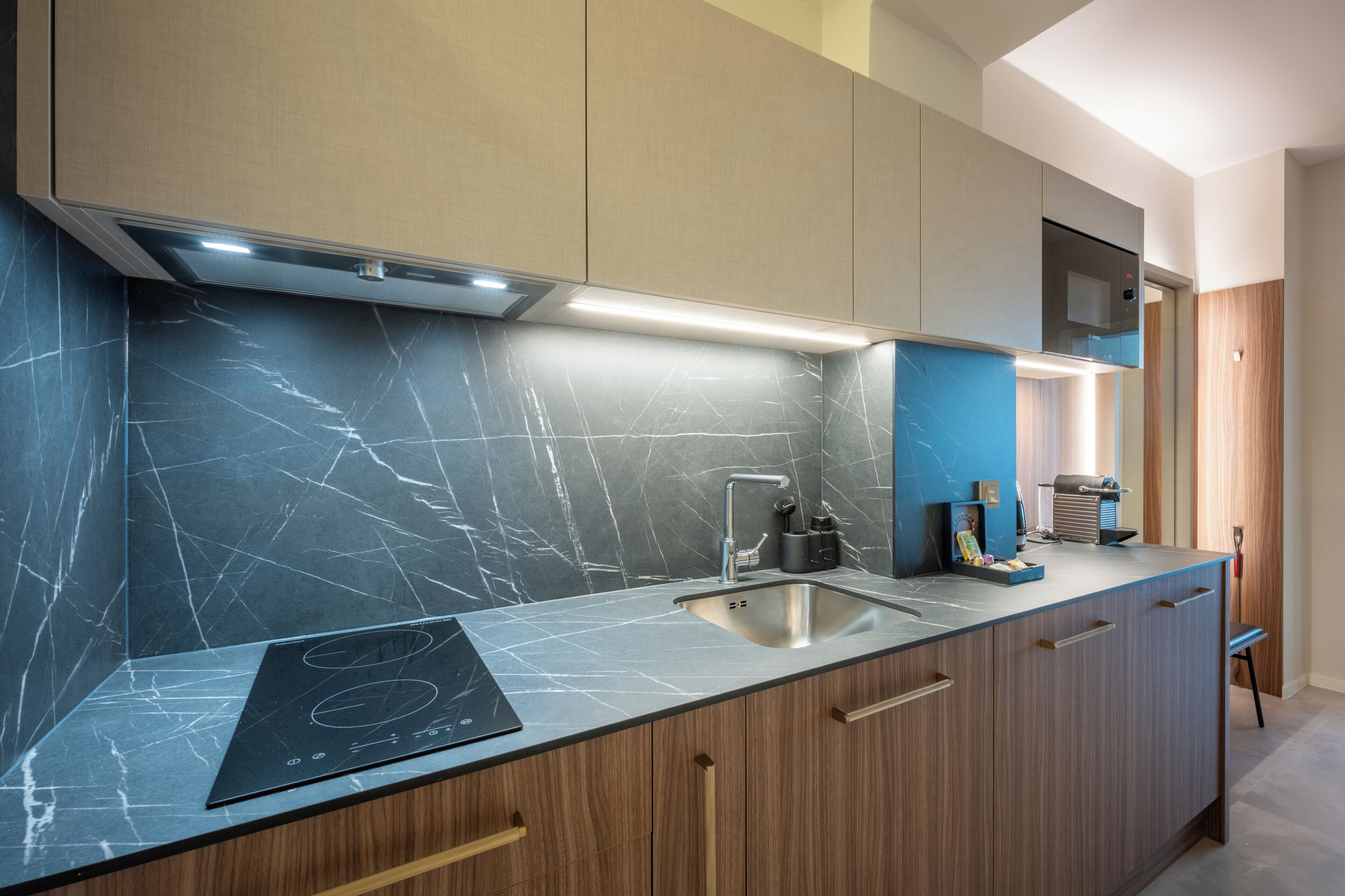Una cocina moderna con estufa integrada, un lavamanos y armarios de madera.