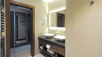 A bathroom with two sinks, a mirror, and a towel rack.