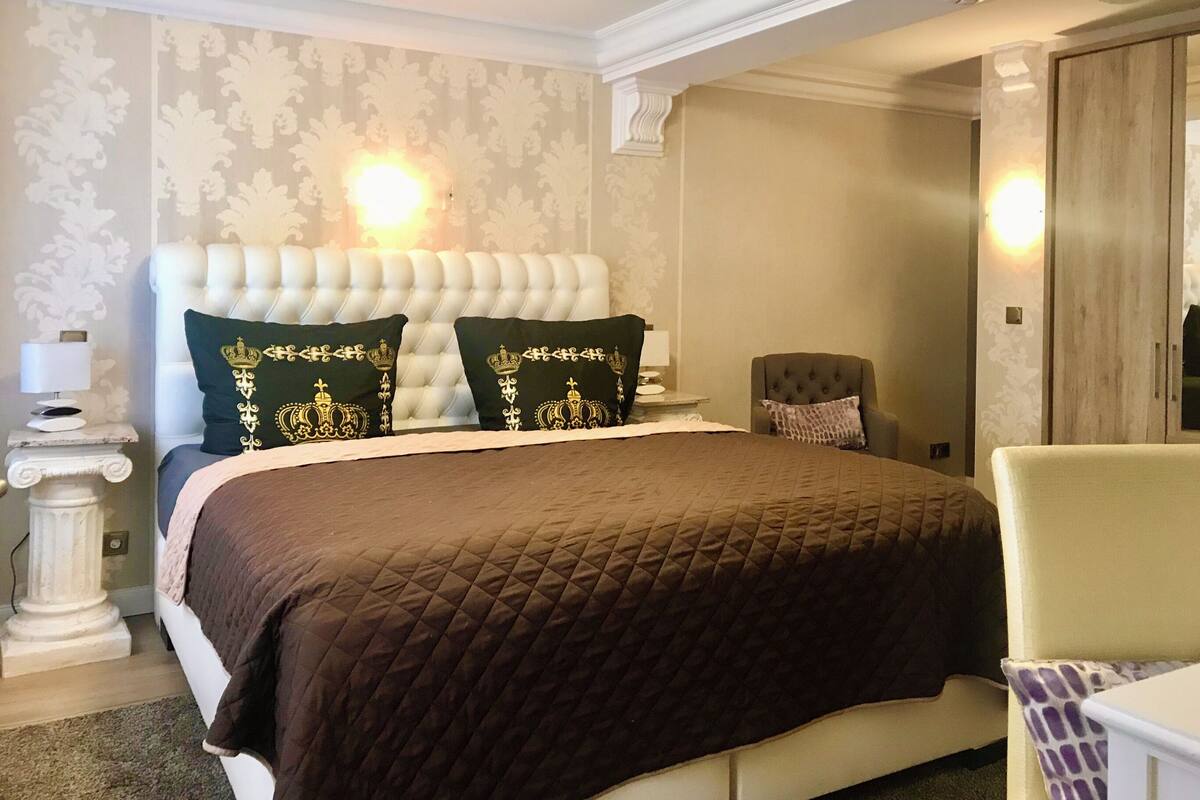 Ein Schlafzimmer mit einem großen Bett, einem Nachttisch, einem Stuhl und einem Kleiderschrank.