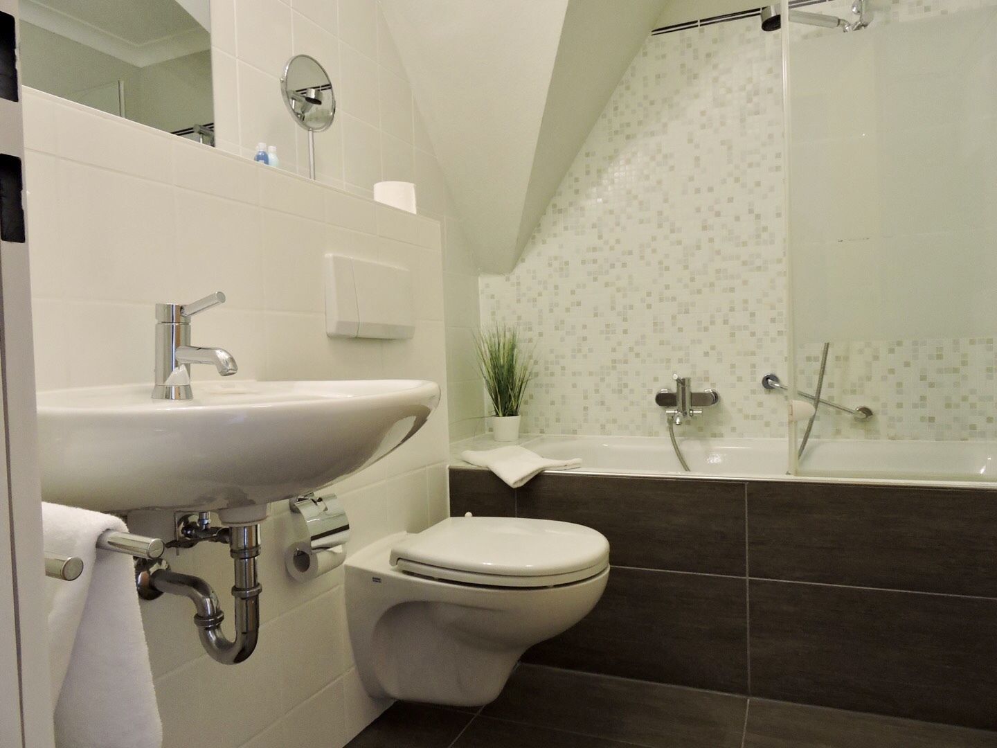 A modern bathroom with a sink, toilet, and bathtub.
