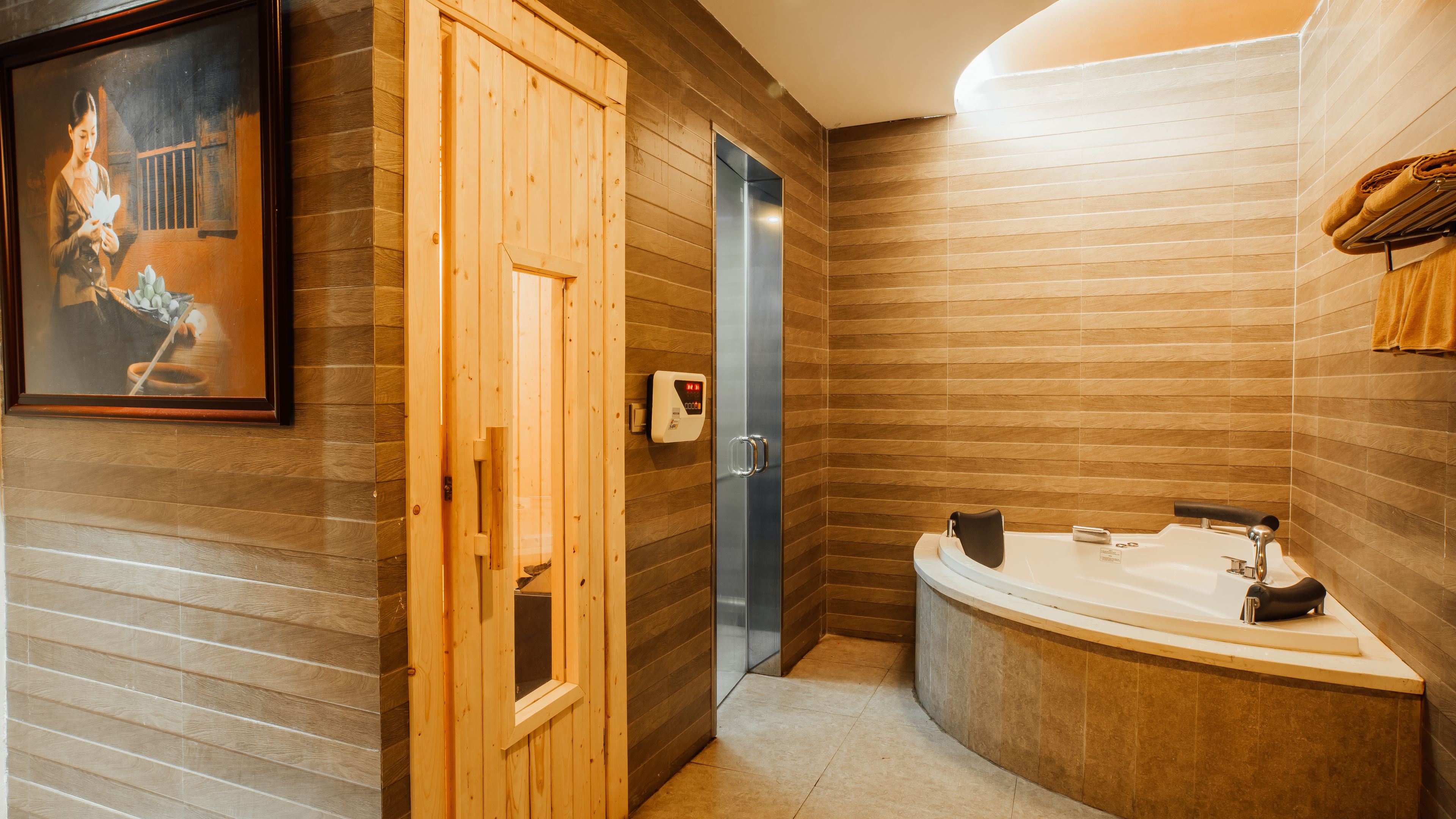 A modern bathroom with a wooden panel wall, a large bathtub, and a wooden door.