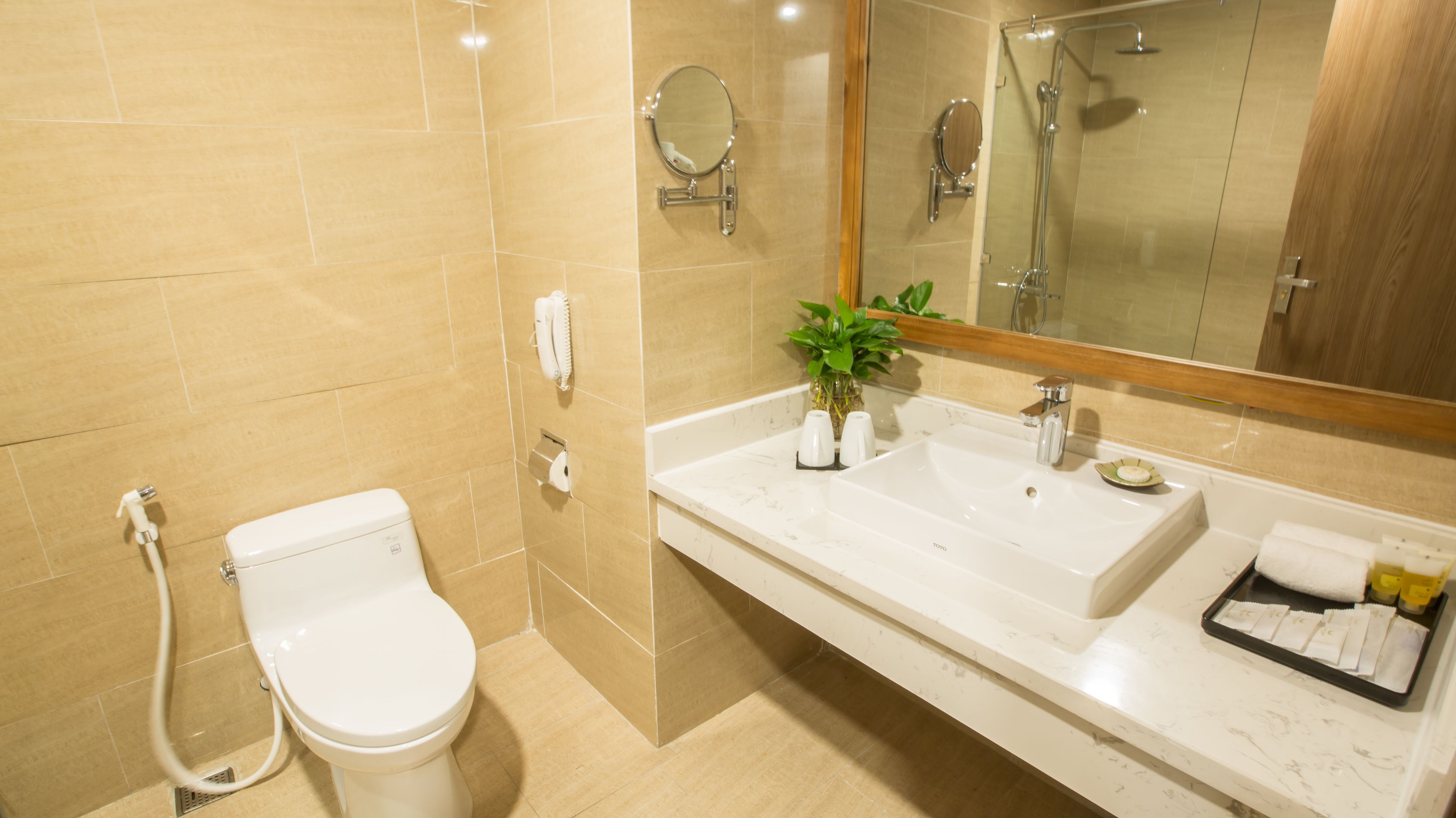 Een moderne badkamer met toilet, wastafel en douche.