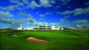 A large building with a modern design, situated on a golf course with bunkers and a clear blue sky. - The Warwick Southport (Southport)