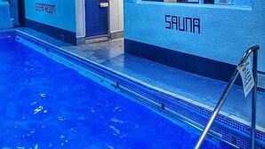 A swimming pool with a tiled edge and a sign indicating a sauna area. - The Warwick Southport (Southport)