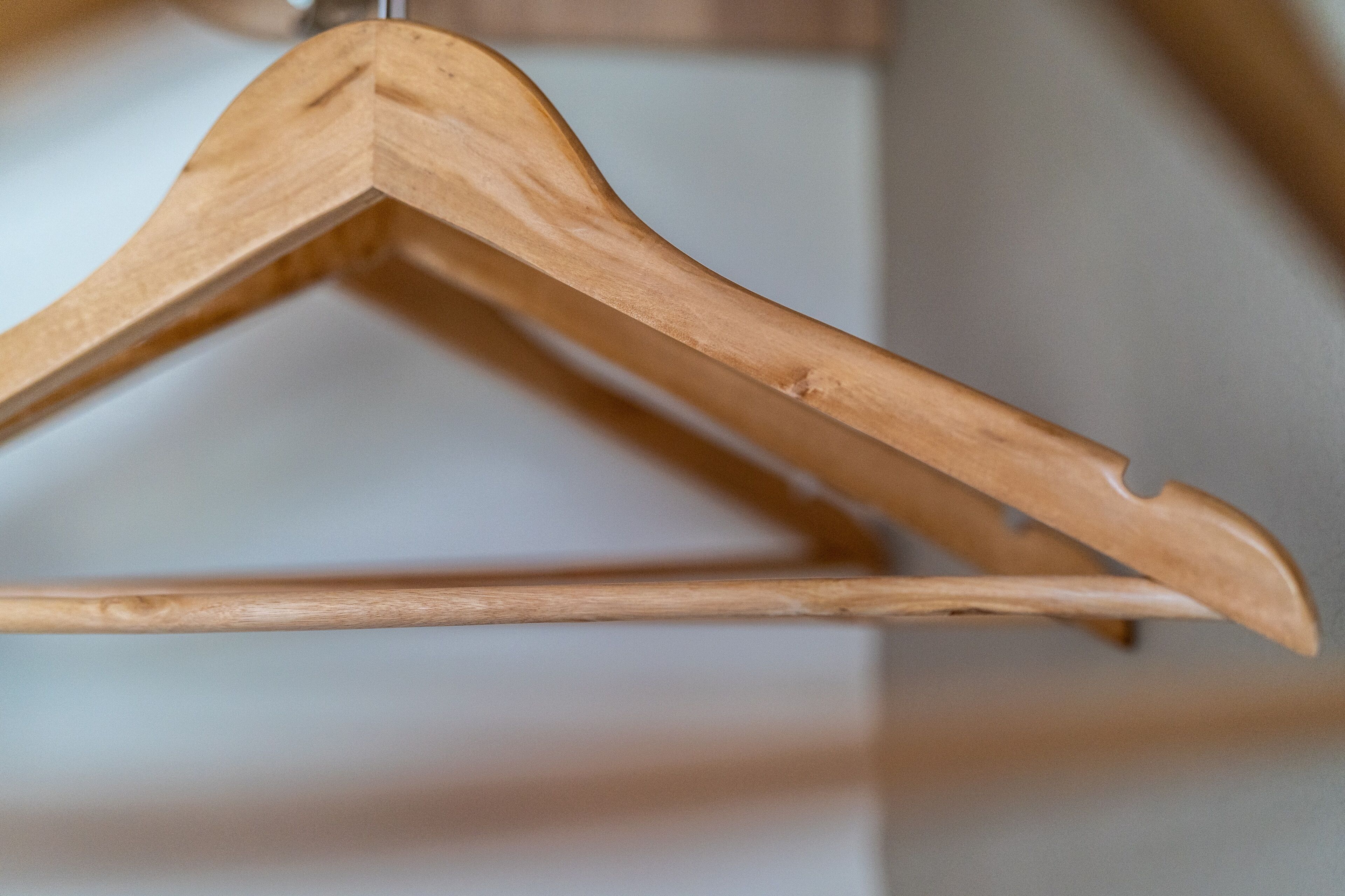 A wooden hanger with a simple design, likely used for hanging clothes.