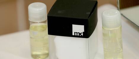 A bathroom with a white sink, a black and white box, and two bottles of liquid.