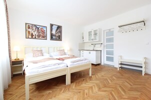 Un dormitorio con cama doble, mesita de noche, cómoda, armario y banco.