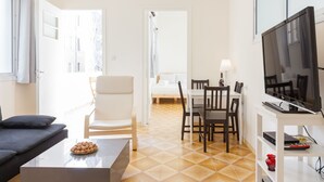 Een moderne woonkamer met een bank, salontafel en een eethoek met stoelen en een tafel.