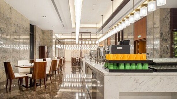 A modern hotel lobby with marble floors, wooden chairs, and a reception desk. - Wuhan Sentai Zhongyang Hotel (Wuhan)
