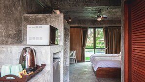 A modern room with a bed, a desk, and a kitchenette area. - Stucco Loft Residency (Chiang Mai)