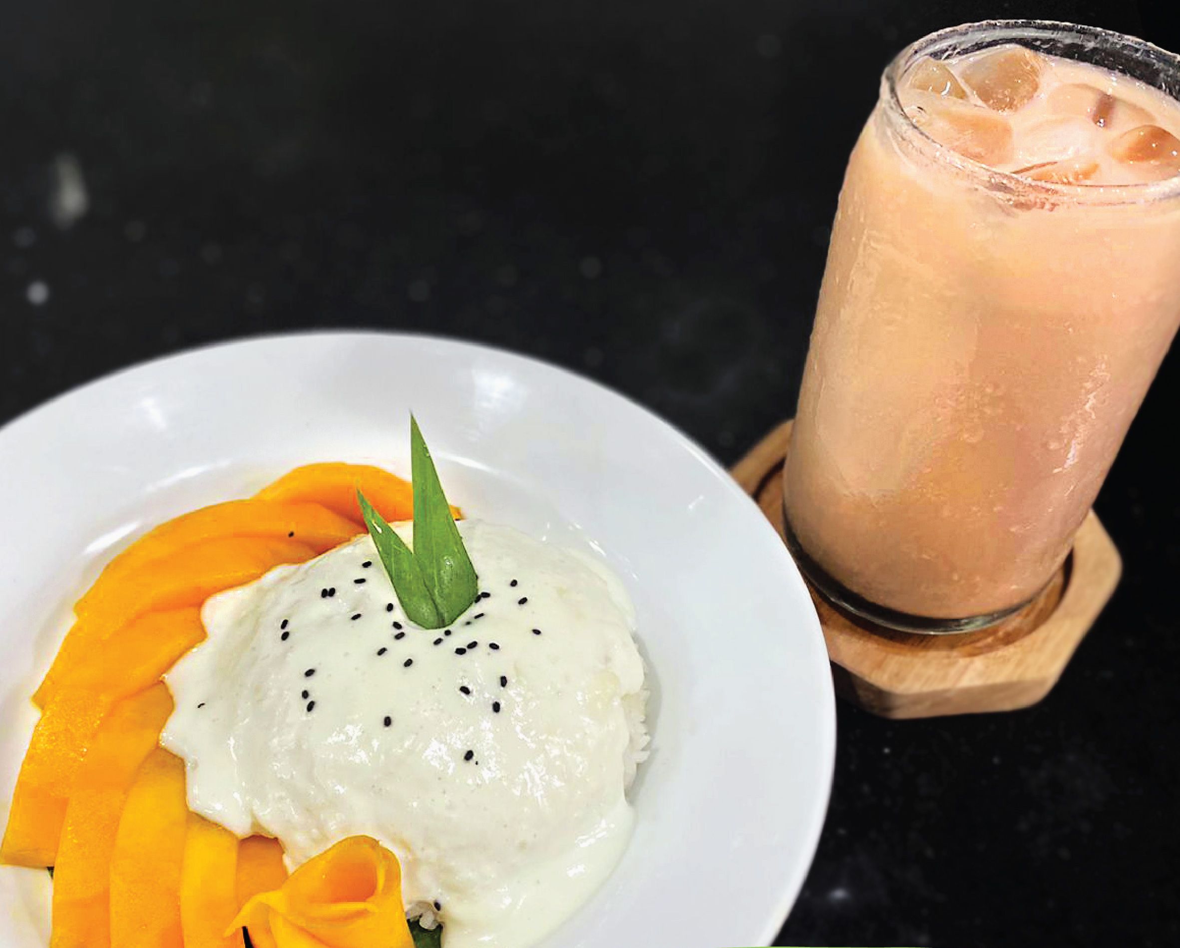 A plate of mango sticky rice with a glass of Thai tea.
