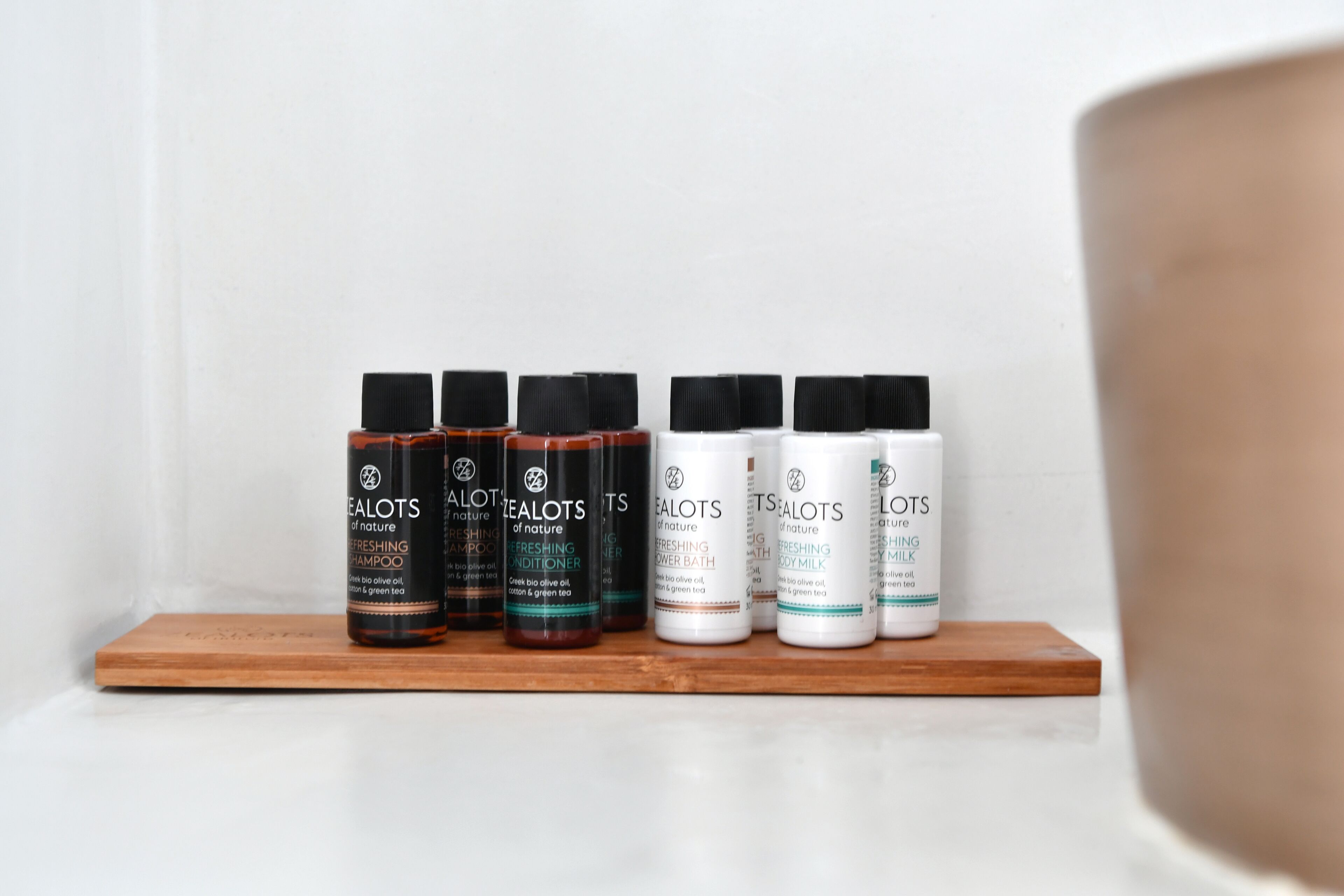 Uma prateleira com cinco frascos de produtos 'Realots of Nature', incluindo shampoo, condicionador, gel de banho e loção corporal.