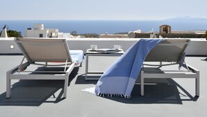 Twee comfortabele stoelen met uitzicht op zee en bergen.