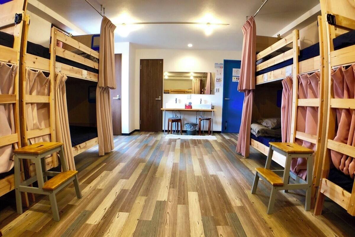 A room with bunk beds, a desk, and a mirror.