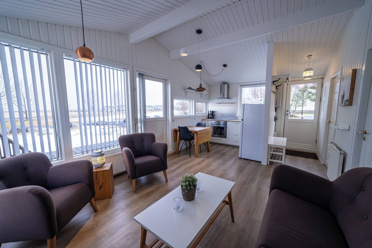 Ein modernes Wohnzimmer mit Sofa, Couchtisch und einem Essbereich mit Tisch und Stühlen.