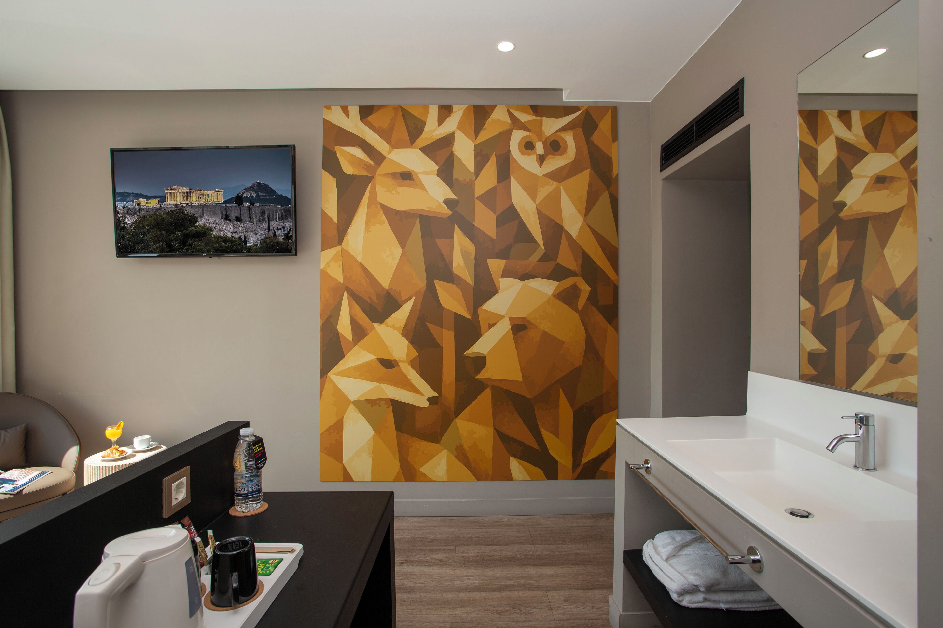 A modern bathroom with a geometric wall mural, a sink, and a mirror.