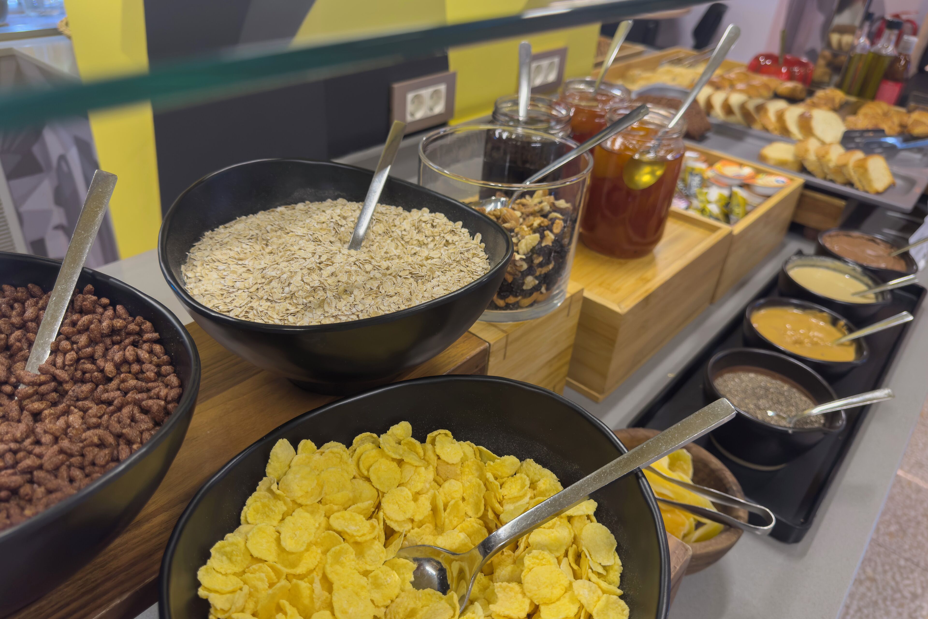 A buffet with various food options including cereals, nuts, and dips.
