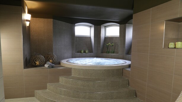 A spa area with a hot tub, steps leading to it, and two windows providing natural light. - Villa Grohmann (Lipova-Lazne)