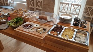 A buffet table with various food items and utensils. - Villa Grohmann (Lipova-Lazne)