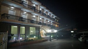 A multi-story hotel with balconies, a covered entrance, and a parking area. - Hotel Anesi (Metamorfosi)