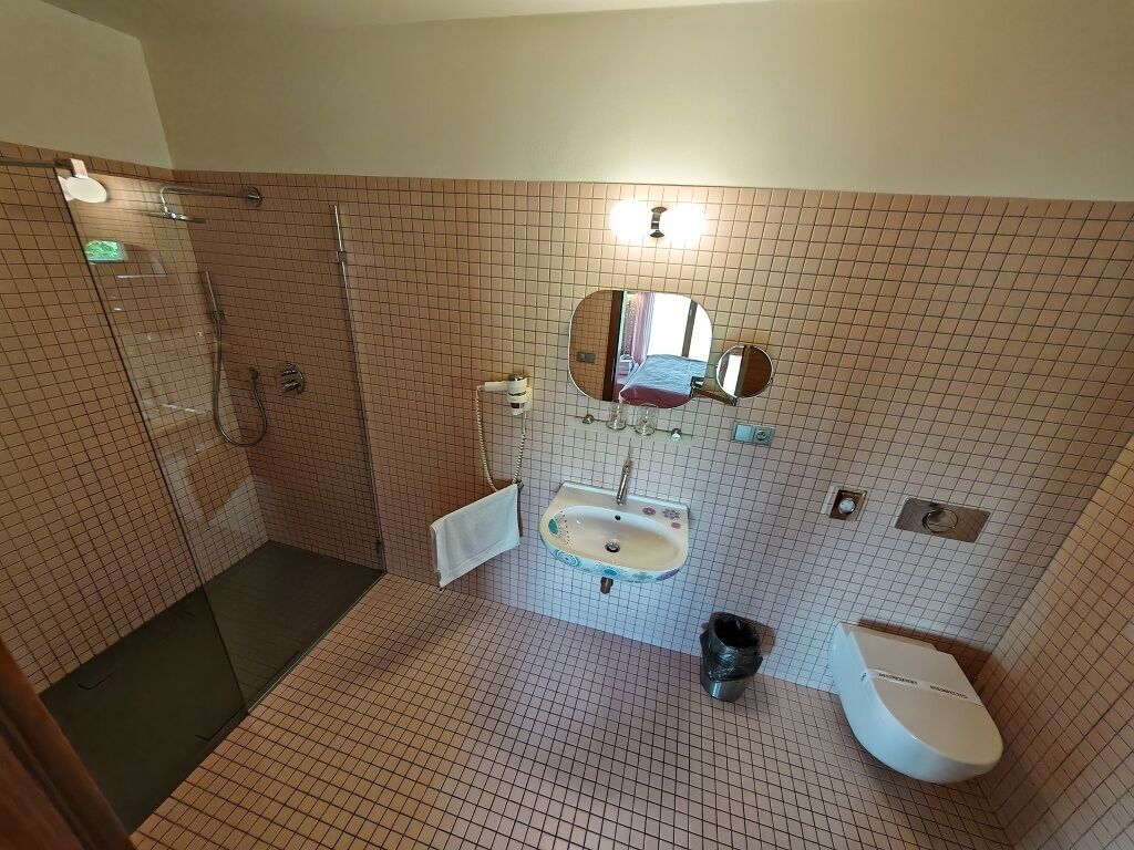 A bathroom with a shower, sink, and toilet.