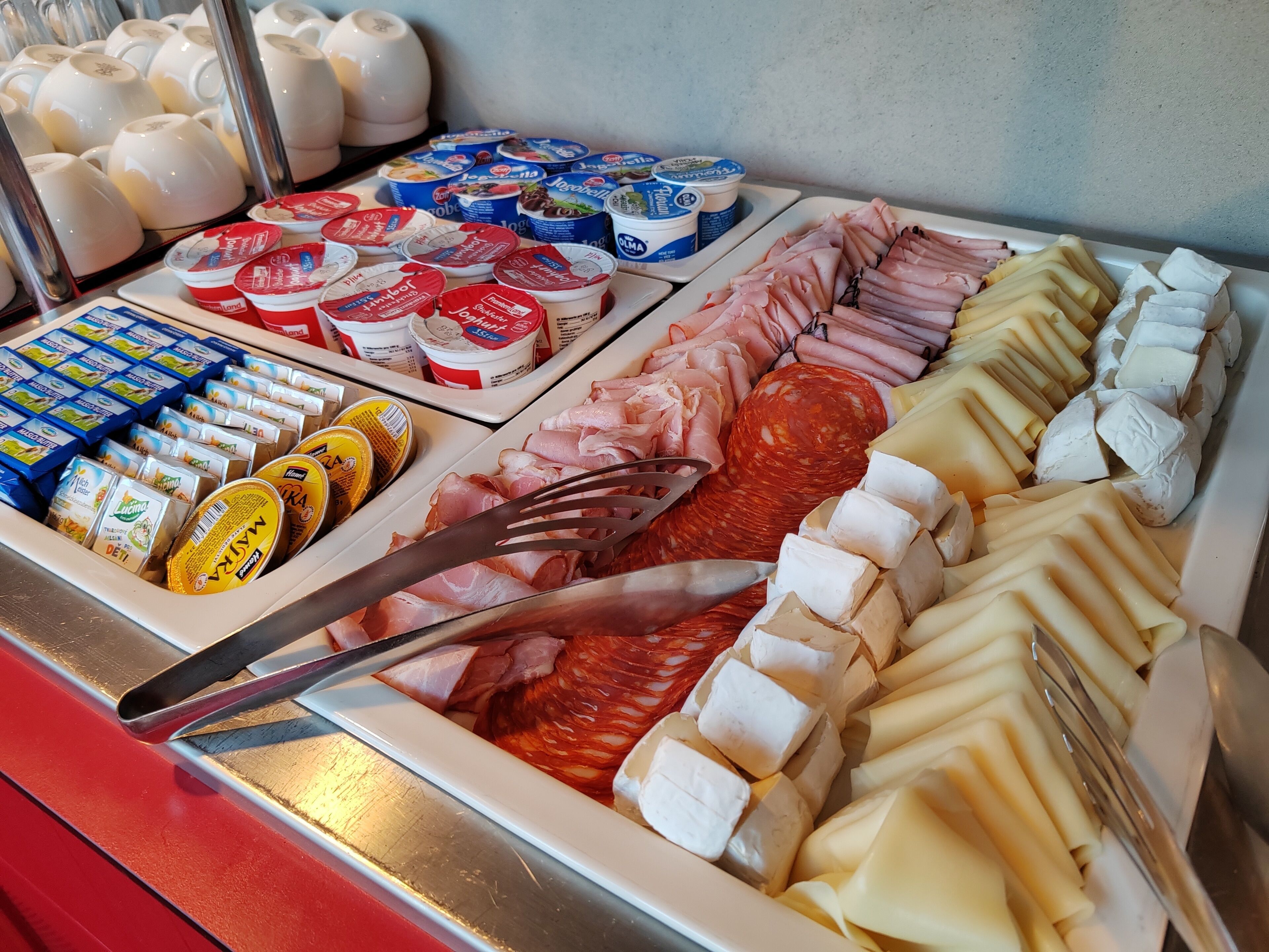 Un mostrador de charcutería con diversos quesos, embutidos y productos lácteos envasados.