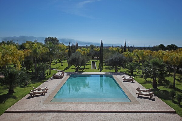 Alberca al aire libre y camastros 