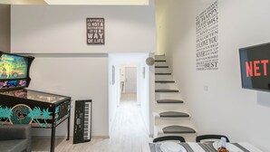 A modern living room with a piano, a television, and a wall with motivational quotes. - happy home Budapest JOY (Budapest)