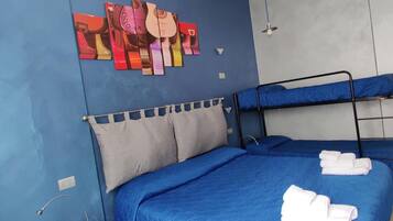 A room with two bunk beds, a blue wall, and a guitar-themed artwork.