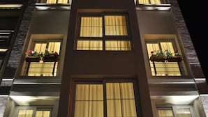 Un edificio de varios pisos con ventanas y balcones iluminados.
