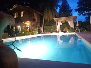 Una piscina con una casa al fondo.