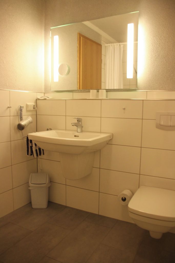 Un baño con lavabo, inodoro y espejo.