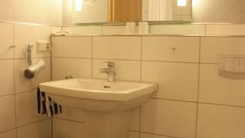 Un baño con lavabo, inodoro y espejo.