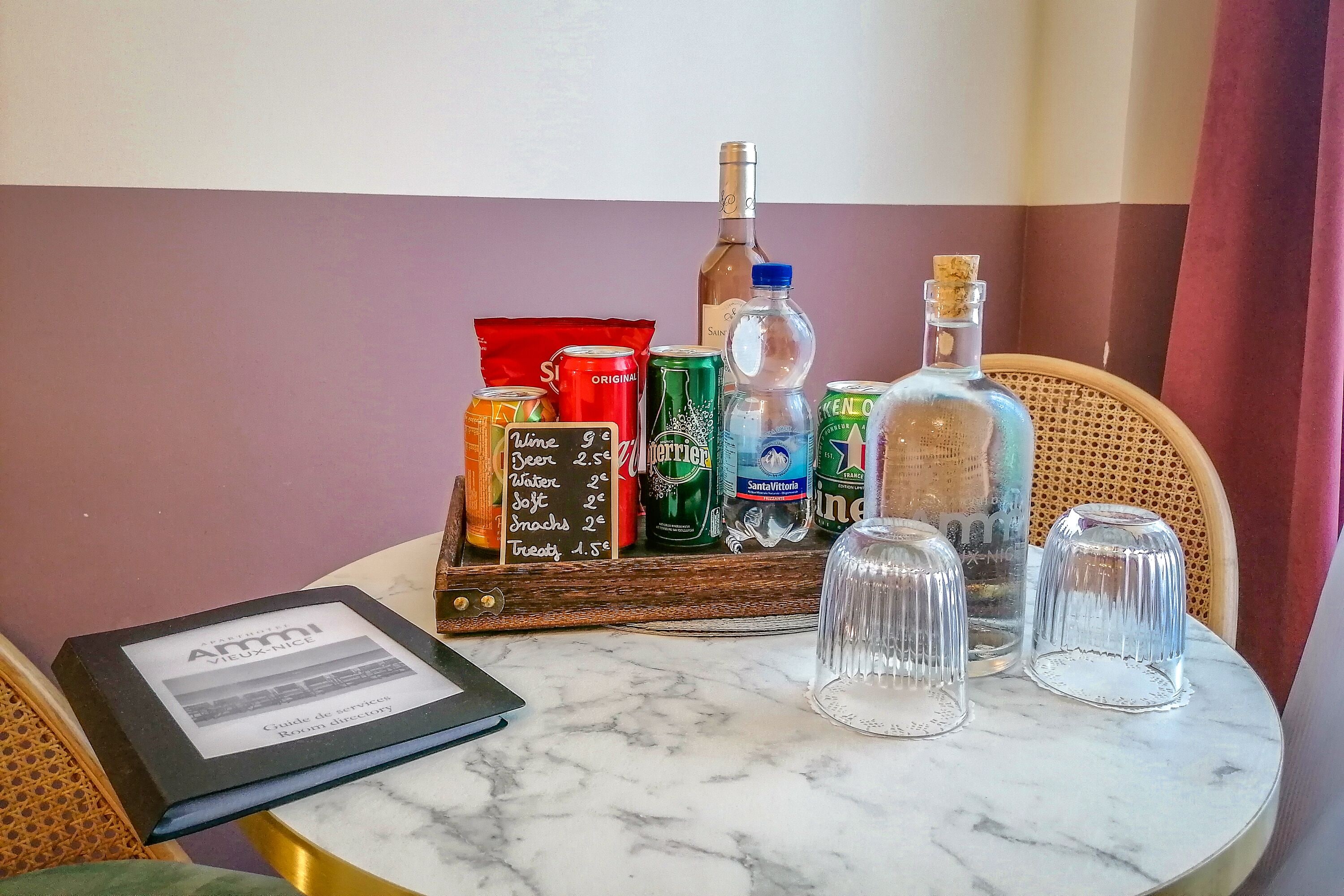 A table with a menu, bottles, and glasses, indicating a bar area in a hotel.