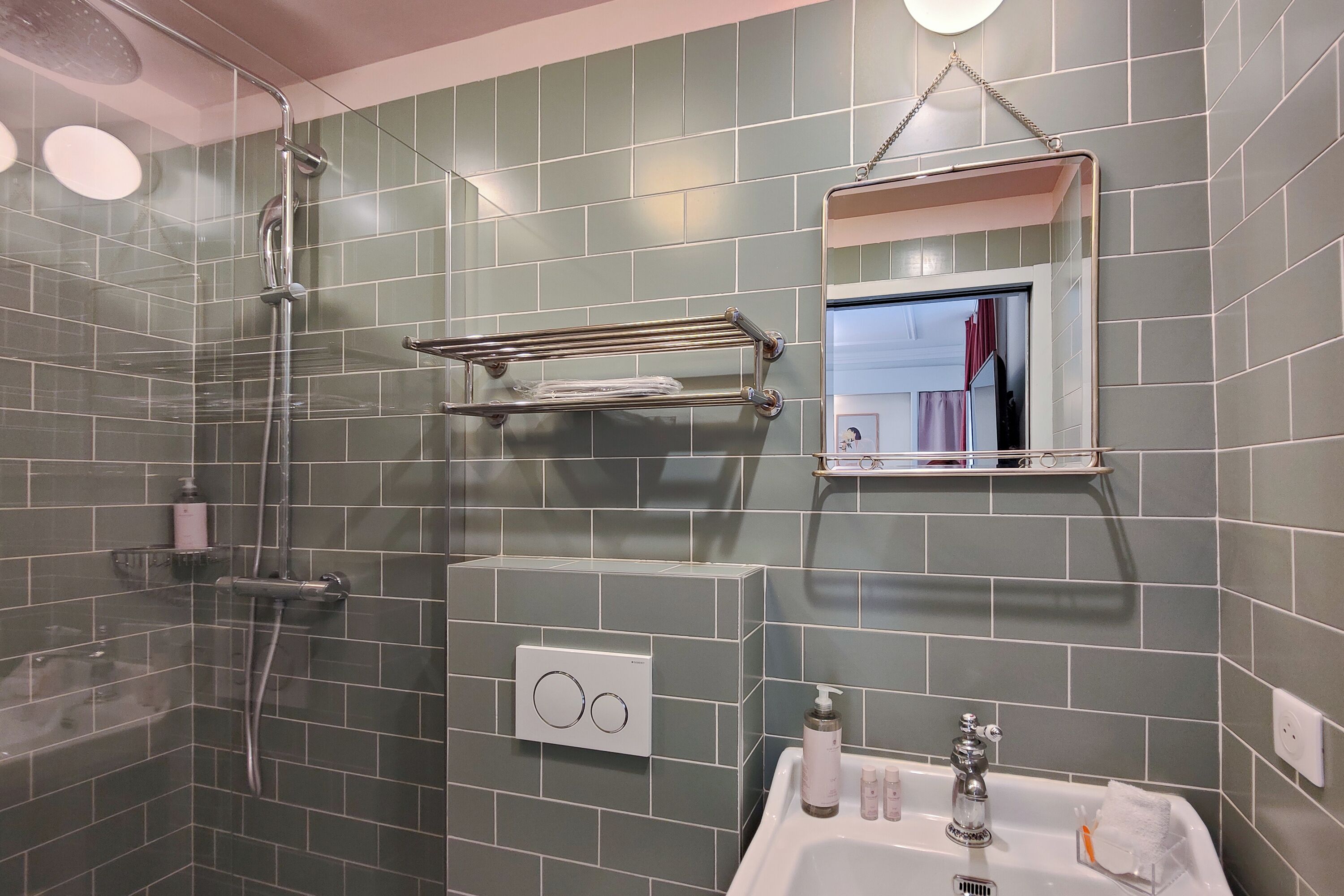 A bathroom with a shower, a sink, and a mirror.
