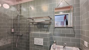 A bathroom with a shower, a sink, and a mirror.