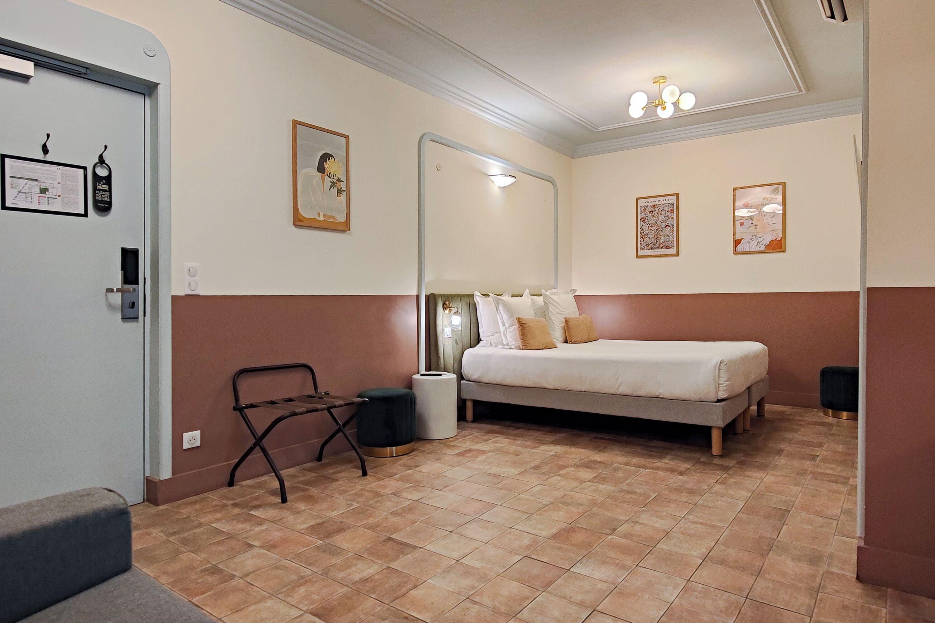 A bedroom with a bed, a chair, a trash bin, and a mirror.
