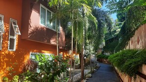 A narrow alleyway flanked by buildings with balconies and lush greenery. - The Chalet Phuket Resort (Wichit)