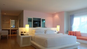 A modern bedroom with a large bed, bedside tables, a desk, and a seating area by the window. - The Chalet Phuket Resort (Wichit)