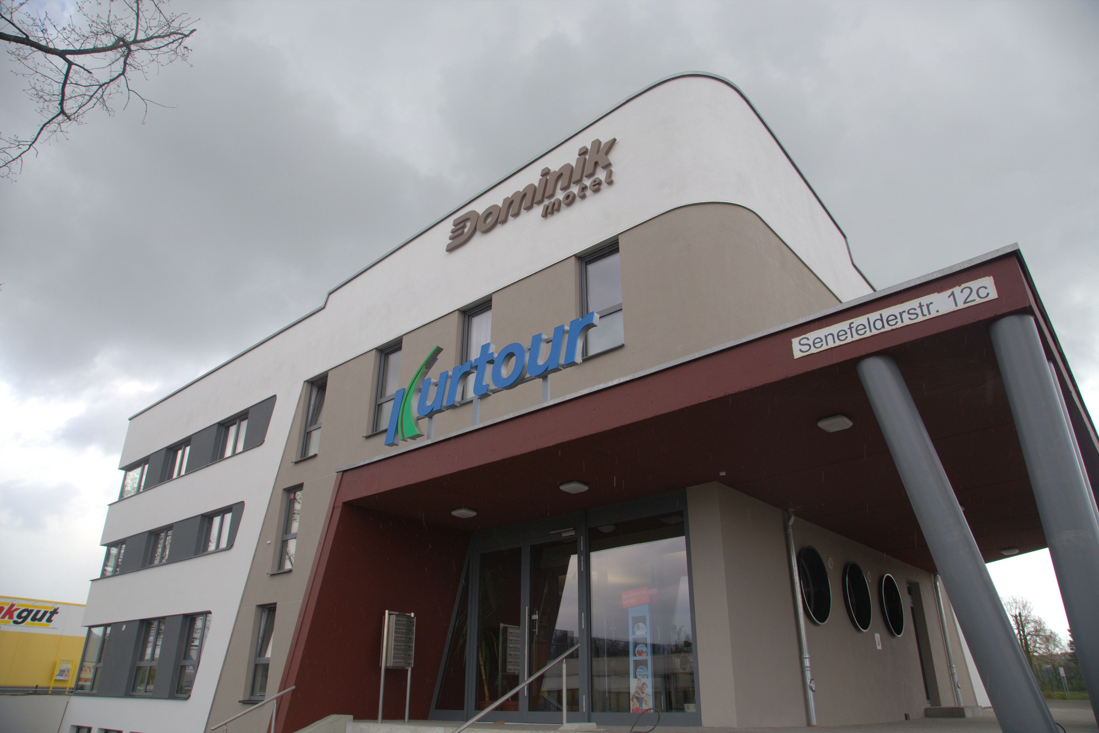 A building with a sign for 'Dominik Motel' and 'Kurtor'.