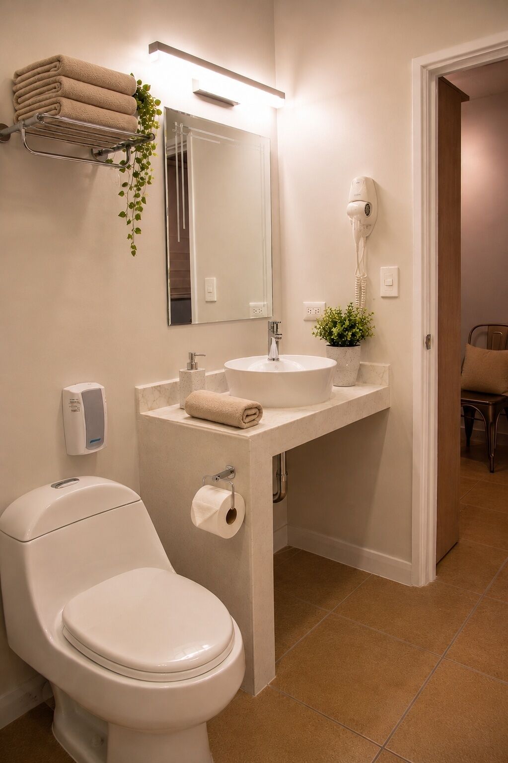 A bathroom with a toilet, sink, mirror, towel rack, and a hairdryer.