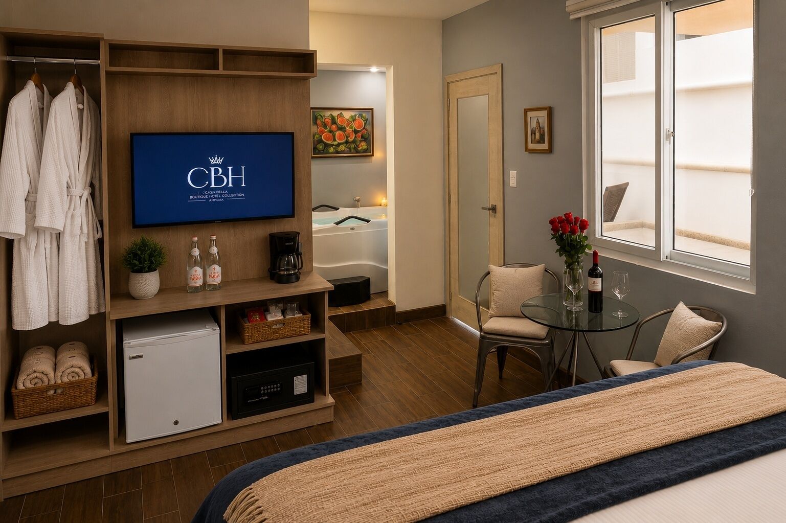 Une chambre d’hôtel équipée d’une télévision diffusant la chaîne « CBH », d’une baignoire, d’une petite table sur laquelle est posé un vase de fleurs, d’une chaise et d’un lit recouvert d’une couverture bleue et beige.