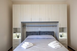 A hotel room with a bed, bedside tables with lamps, a wardrobe, and a headboard. - L'Incanto dei Monti (Agerola)
