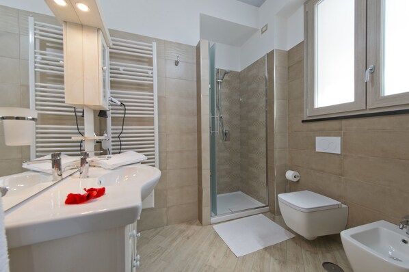 Habitación doble | Baño | Regadera, amenidades de baño gratuitas, secadora de cabello, bidet 