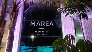 Het uiterlijk van Marea Avarthotel, met een opvallend bord en een zwembadgedeelte zichtbaar op de achtergrond.