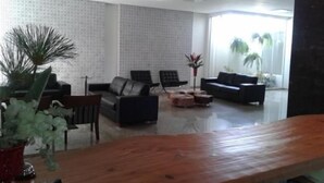 Una sala de estar moderna con un ventanal grande, una mesa de centro de madera y un sofá.