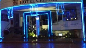 Exterior del Hotel Cristal, con fachada curva e iluminada por luces de neón azules.