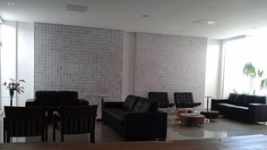 Una sala de estar moderna con un sofá, sillas y una mesa de centro.