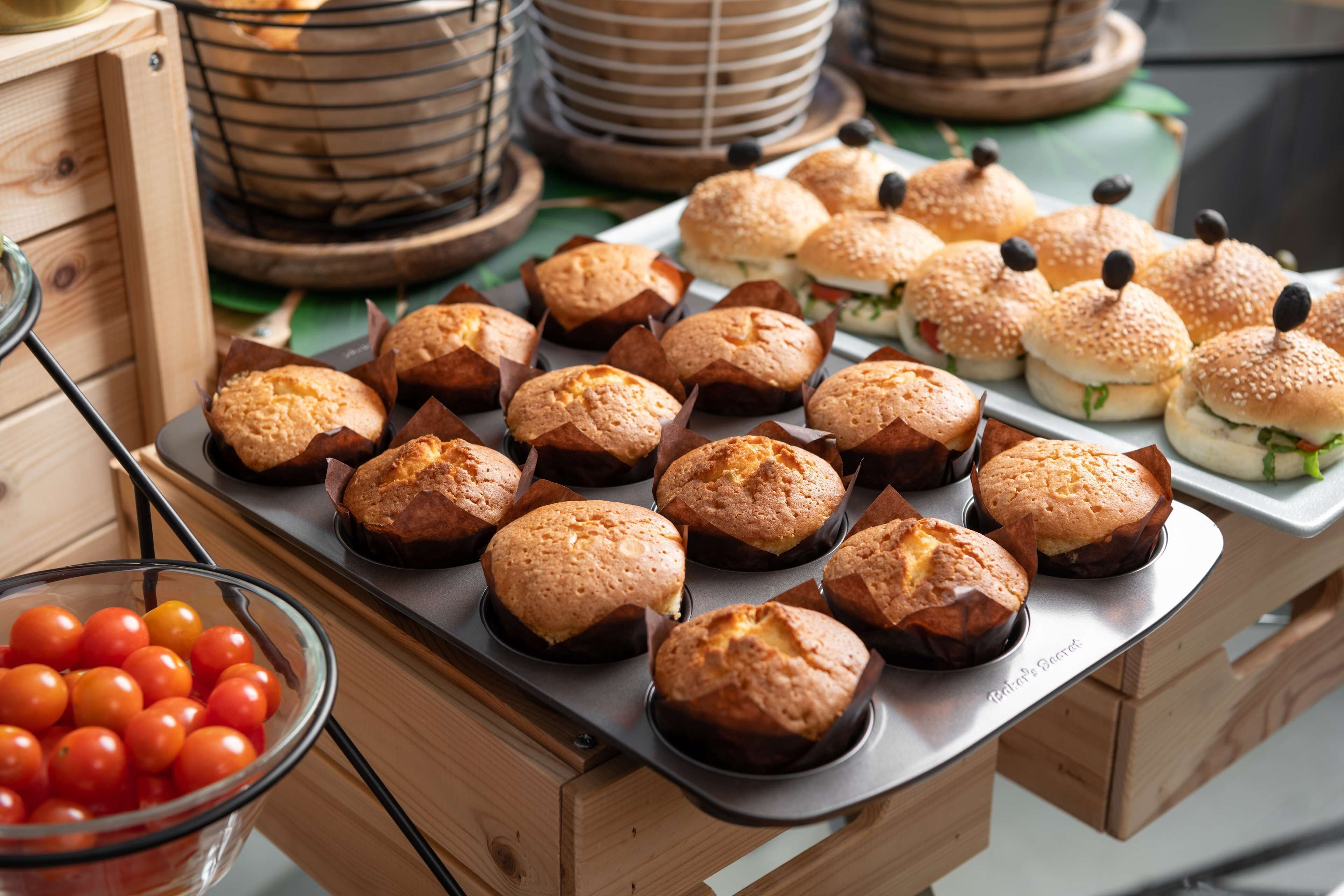 Ett fat med muffins och smörgåsar på ett träbord.